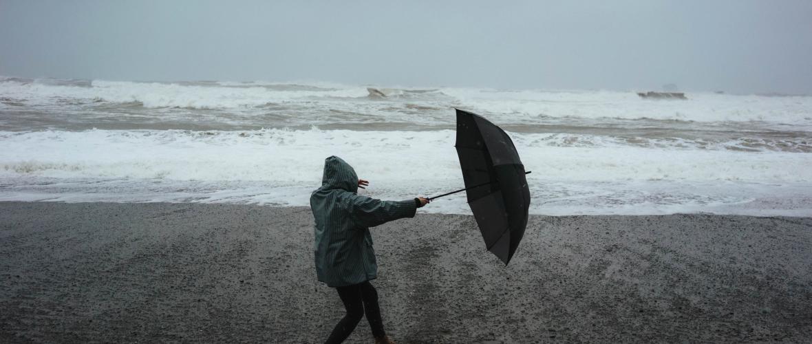 Storm op het strand man met paraplu